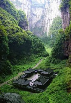 a large building in the middle of a lush green valley