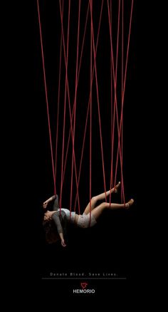 a woman hanging upside down in the air with red lines coming out of her body