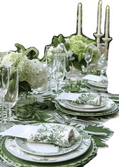 the table is set with green and white plates, napkins, and silverware