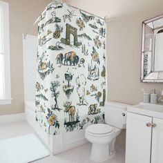 a bathroom with a shower curtain that has animals on it