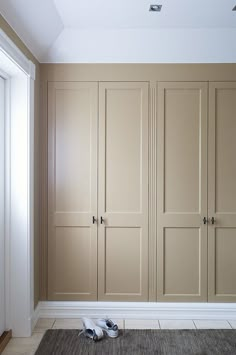 a pair of shoes sitting on the floor in front of some closets with doors