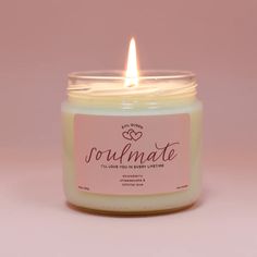 a white candle with a pink label on it that says soulmate, i love you in another language