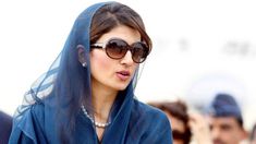 a woman wearing sunglasses and a blue shawl