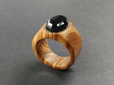 a wooden ring with a black stone in it