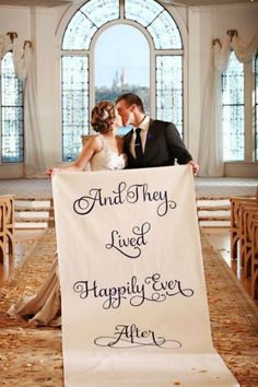 a bride and groom kissing in front of a sign that says, and they lived happily ever after