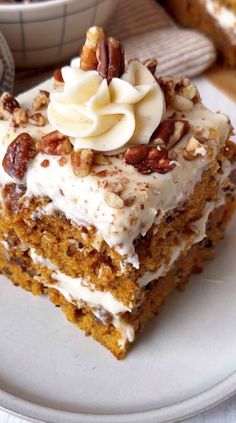 a piece of cake on a plate with nuts and cream frosting in the middle