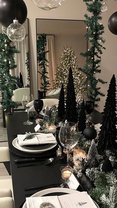 a dining room table decorated for christmas with black and white decorations