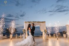 a newly married couple standing under an arch with fireworks