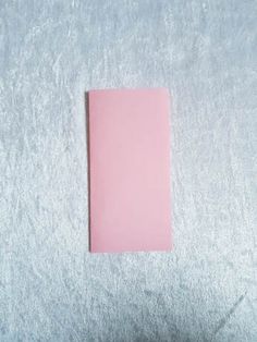 a pink piece of paper sitting on top of a white surface