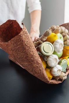 a person holding a paper cone filled with vegetables