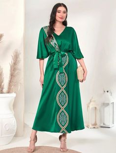 Indulge in opulence with our elegant green batwing kaftan dress, embellished with intricate floral motifs. Crafted from premium 100% polyester, it showcases a belted waist, a flattering V-neck, and a flared hem that highlights the elevated waistline. Effortlessly maintain this dress with machine wash capabilities, making it an ideal addition to any refined wardrobe. Now available in US sizes 4 - 12. This item ships immediately worldwide! Please note that this item is Final Sale, and no returns o Green Belted V-neck Maxi Dress, Elegant Green Dress With Kimono Sleeves, Elegant Green Kaftan For Festive Occasions, Green Belted Evening Dress, Green V-neck Dress For Festive Season, Green V-neck Dress For Festive Occasions, Green Evening Dress With Tie Waist, Festive Green V-neck Dress, Green Embellished Kaftan For Evening