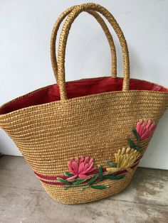 "Vintage straw floral beach bag with stitched raffia lotus blossoms. The bag is lined in a red plastic material. This tote could be used as a small beach bag or a larger summer time purse. Very nice vintage shape, however one of the raffia leaves is not complete. There is also a bit of adhesive residue where there once was either a price tag or manufacturer's tag. Please see all photos. Measurements-at the widest-18\" wide by 12\" tall(not including the handles). The top when opened wide is 9\"x Red Tote Beach Bag For Beach Season, Red Straw Shopping Bags, Handmade Flower-shaped Bag For Vacation, Red Woven Beach Bag, Red Straw Tote Bag, Red Summer Straw Bag For The Beach, Red Summer Straw Bag For Beach, Summer Red Straw Bag For Beach, Red Summer Straw Bag For Shopping