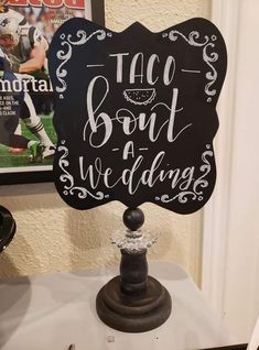 a chalkboard sign that says taco bout and wedding on top of a table