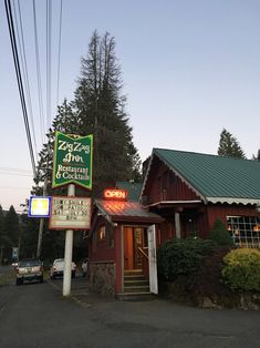 a red building with a green roof next to trees