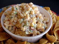 a white bowl filled with potato salad next to tortilla chips