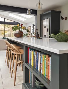 a kitchen with an island and bookshelf filled with books on top of it