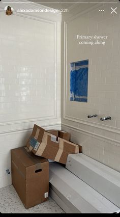 two boxes stacked on top of each other in front of a bathtub and sink