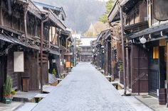 an empty street with wooden buildings and trees