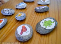 rocks with pictures of animals on them sitting on a wooden table next to each other