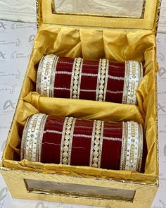 two red and white bangles in a gold box