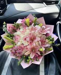 a bouquet of flowers sitting on top of a car dashboard