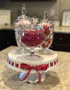 two glass bowls filled with candy on top of a counter