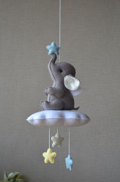 an elephant is sitting on top of a cloud with stars hanging from it's sides