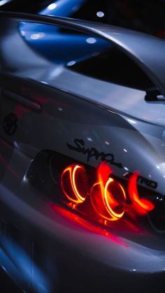 the tail lights of a silver sports car