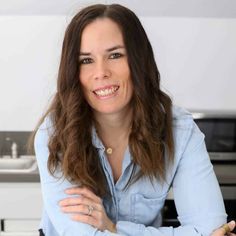 a woman sitting at a table with her arms crossed in front of the counter top