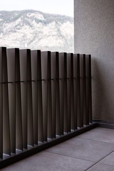 a window with vertical blinds in front of a mountain view