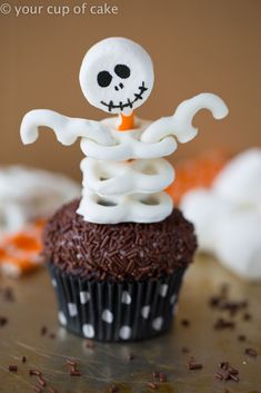 a cupcake decorated with white icing and a skeleton on top