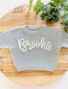 PERSONALIZED BABY, TODDLER & KID'S HAND EMBROIDERED KNIT SWEATER These customizable sweatshirts are such a beautiful piece to share with the littles in your life. They can also be used for pregnancy and birth announcements and, make an amazing baby shower or birthday gift too! ABOUT ME: *The lettering is unique to each sweatshirt and stencilled in the appropriate sizing. Each name is hand-embroidered with a high-quality wool yarn. *All items are hand-embroidered so no two designs are the same! Y Playful Knitted Crew Neck Top, Playful Long Sleeve Customizable Tops, Customizable Cute Crew Neck Sweater, Cute Customizable Crew Neck Sweater, Fall Sweater With Name Print And Crew Neck, Fall Crew Neck Sweater With Name Print, Baby Sweater With Name, Name Sweater Baby, Embroidery Sweaters