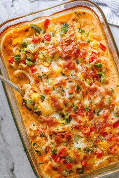 a casserole dish filled with cheese, tomatoes and other toppings on a marble surface