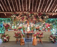 a table with flowers and candles on it in front of a decorated area for an event