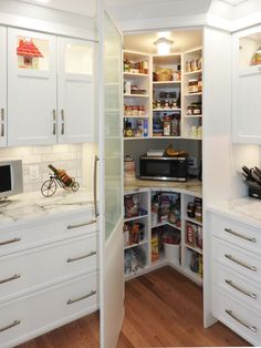 a kitchen with white cabinets and lots of counter space, including a microwave in the corner