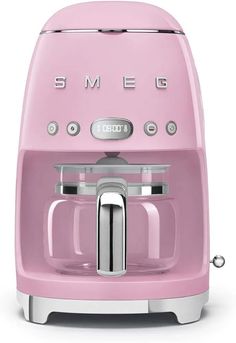 a pink coffee maker sitting on top of a white table