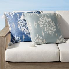 a couch with pillows on top of it in front of a blue and white wall