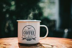 a white coffee mug sitting on top of a wooden table