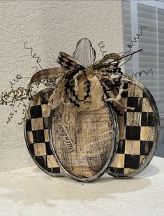 a wooden pumpkin decorated with black and white checkerboard designs on it's side