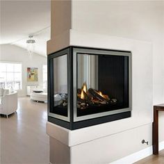 a modern fireplace in the middle of a living room with white walls and wood floors