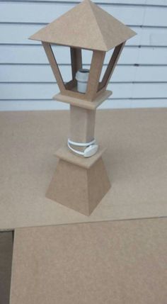 a paper model of a lamp on top of a cardboard box next to a wall