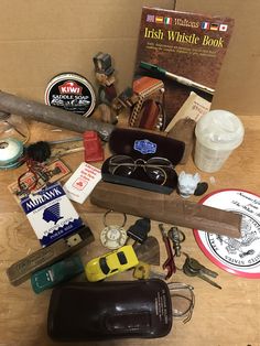 an assortment of items are sitting on a table next to a book and some glasses