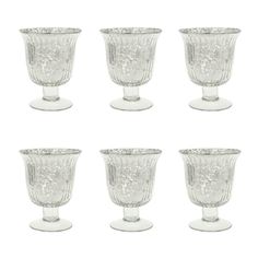 six clear glass goblets sitting next to each other