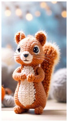 a crocheted squirrel is standing on its hind legs and has it's front paws crossed