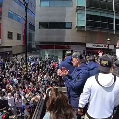 a crowd of people standing on top of an escalator in front of a building