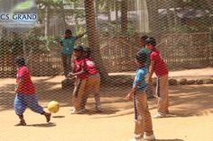 children are playing with a ball behind a chain link fence at the schoolyards