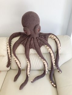 an octopus stuffed animal sitting on top of a white couch