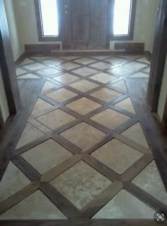 an empty room with two windows and tile flooring on the ground in front of it