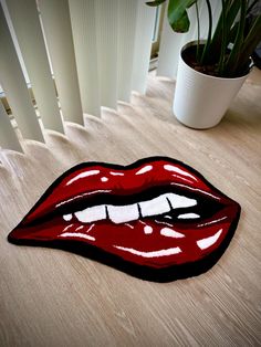 the rug is shaped like a mouth with red lipstick on it's lips and white teeth