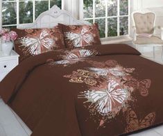 a bed with brown and white butterflies on it